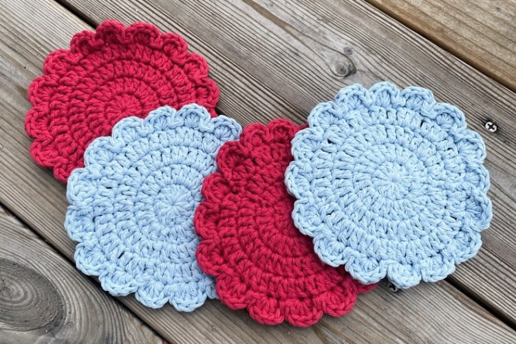 Blumen Untersetzer gehäkelt pink und blau vor Holz